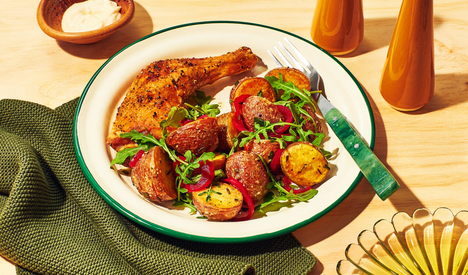 Plate with baby potatoes and roasted chicken on table.